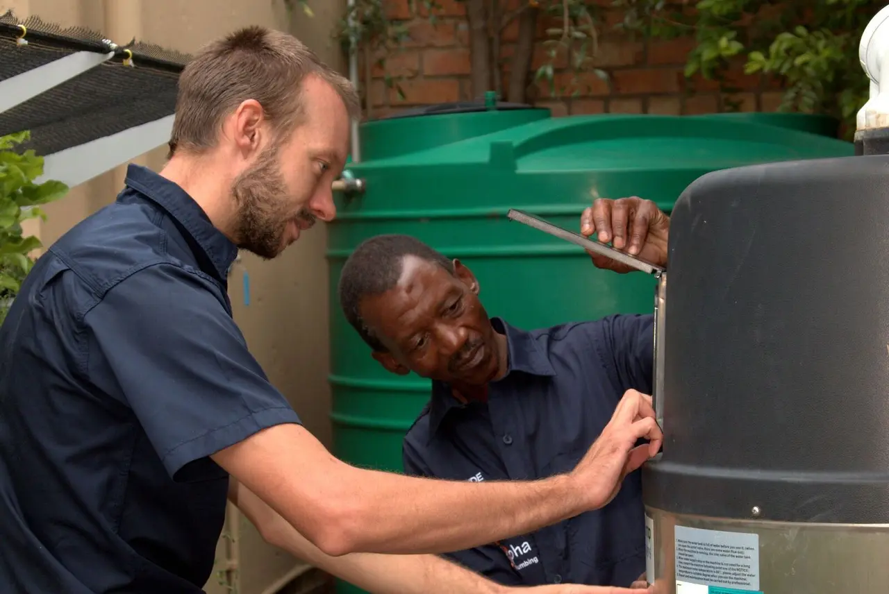 Alpha Plumbing technicians installing a heat pump system in Johannesburg